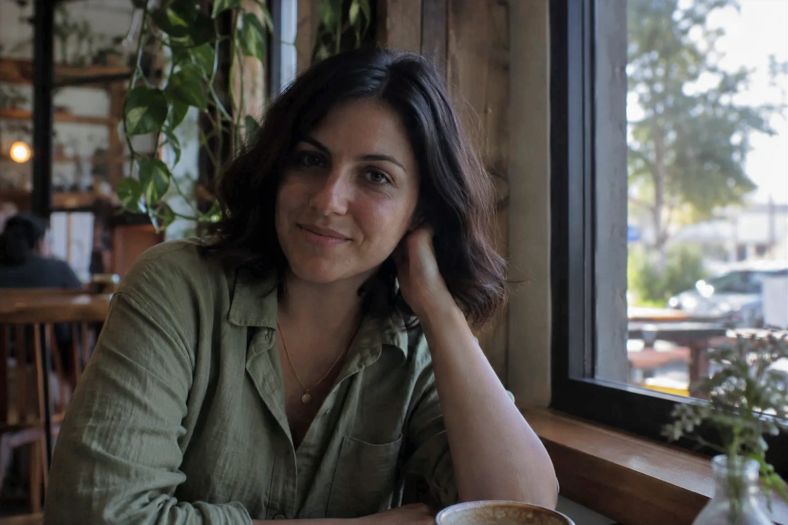 The same AI-generated café portrait after automatic exposure correction