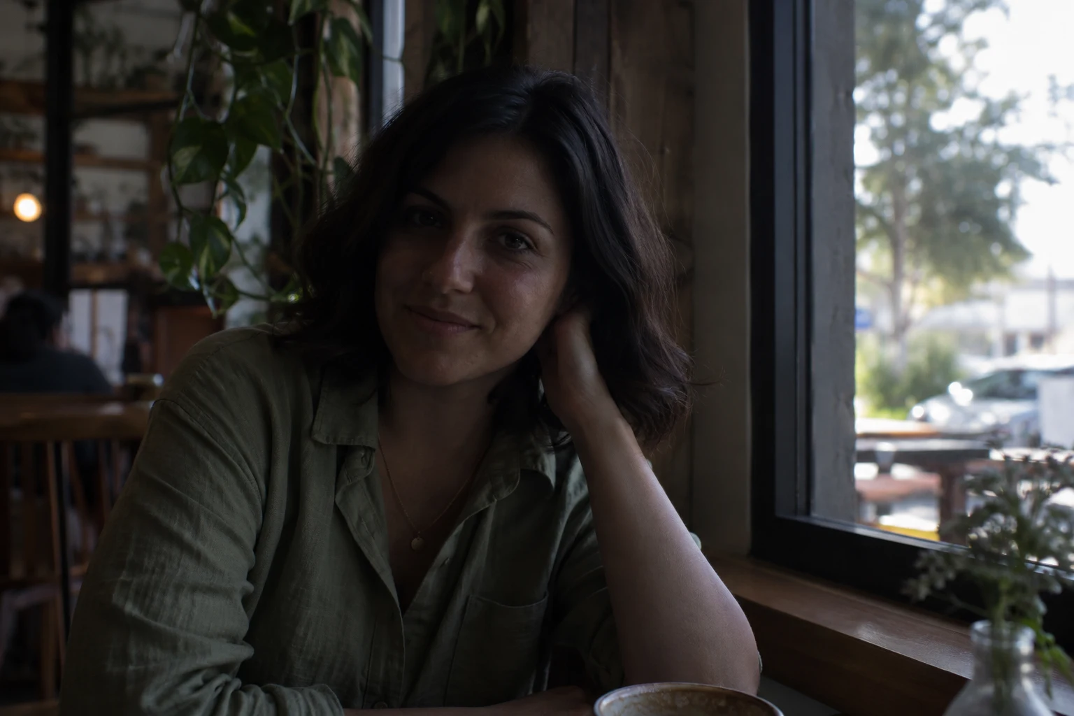 AI-generated underexposed café portrait used as input to the image brightener
